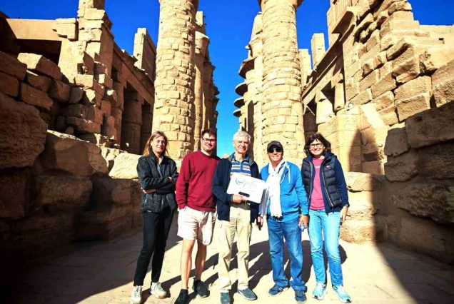 Reisegruppe mit Peter-Tours-Schild zwischen den Säulen des Karnak-Tempels